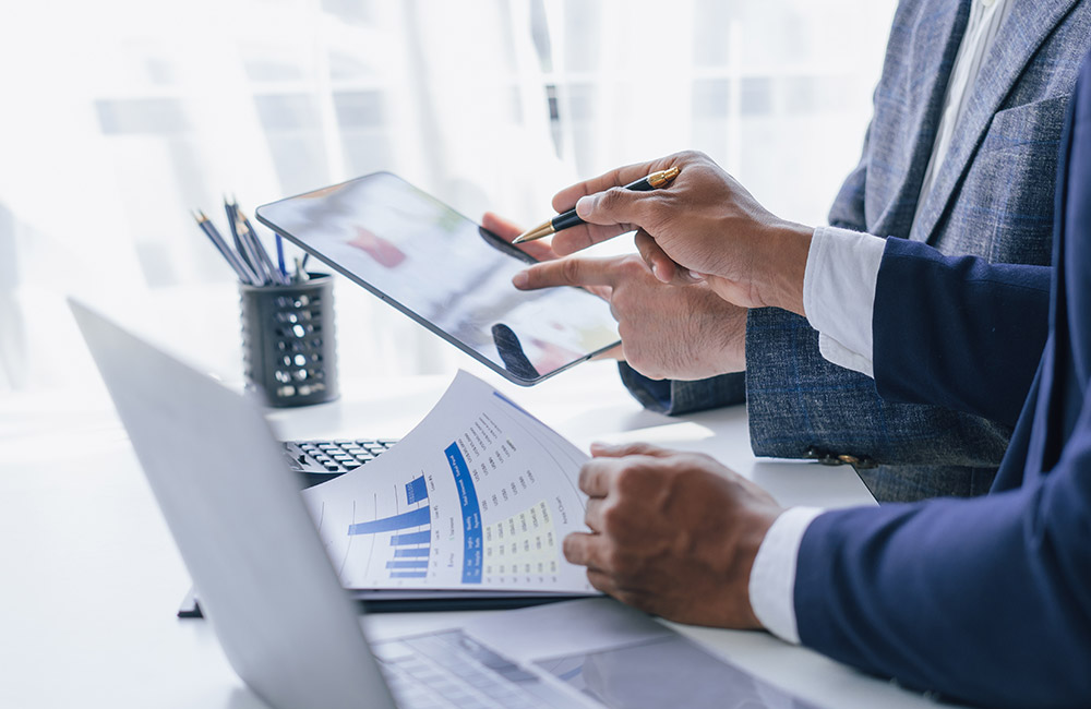 Deposito titoli: cos'è e come funziona Professionisti analizzano documentazione finanziaria in ufficio, immagine rappresentativa della gestione di un deposito titoli e del portafoglio investimenti.